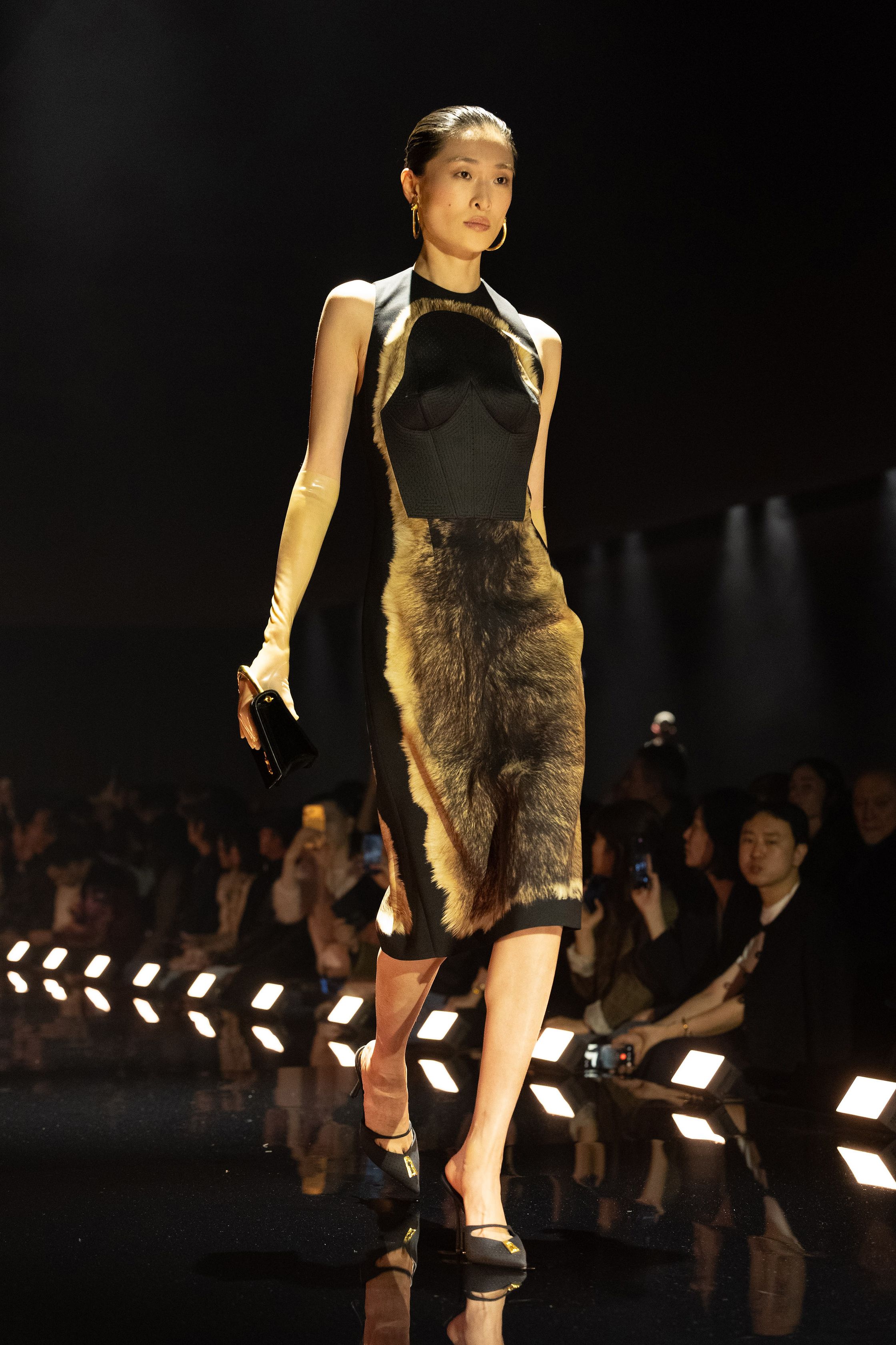 Schiaparelli 2026秋冬系列延续品牌标志性的超现实主义美学，在金色灯光的T台上呈现极具雕塑感的廓形。沙金色与黑金色成为主调，褶皱礼服、雕塑式西装与高腰裙装强化身体线条。经典的金属装饰、夸张肩线以及精致刺绣细节构成强烈视觉符号，使整场秀既华丽又充满戏剧张力。设计师通过结构与面料的张力对比，让高级定制的艺术精神融入现代女性衣橱-顽石频道趋势研究